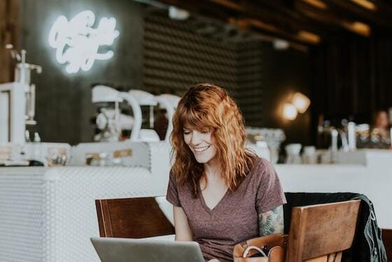 diseno-web-seo-malaga-chica-mirando-su-portatil-sonriendo